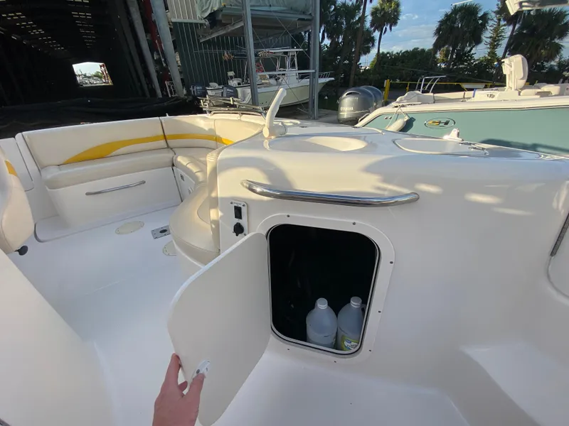 Slide: The Image of 2001 Chaparral Sunesta 232 boat interior with open storage compartment and seating area. - 21