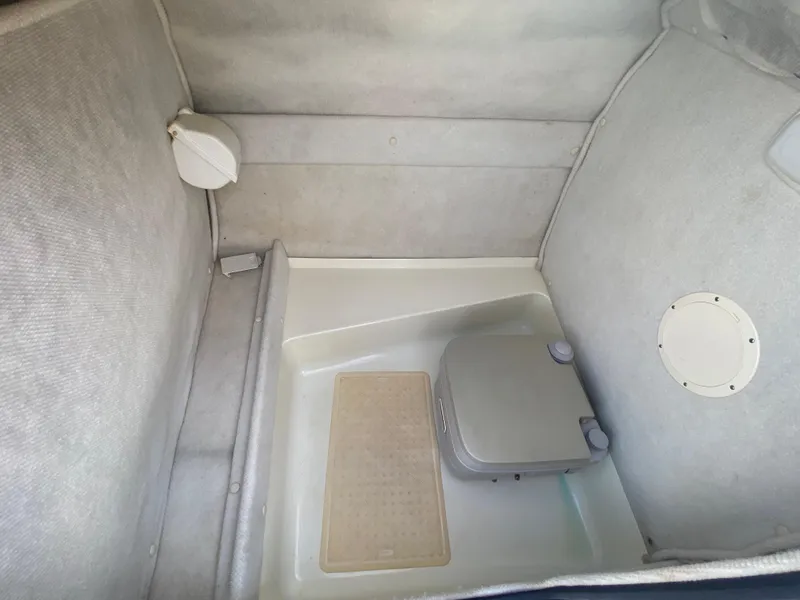 Slide: The Image of 2001 Chaparral Sunesta 232 boat interior with portable toilet and carpeted walls. - 24