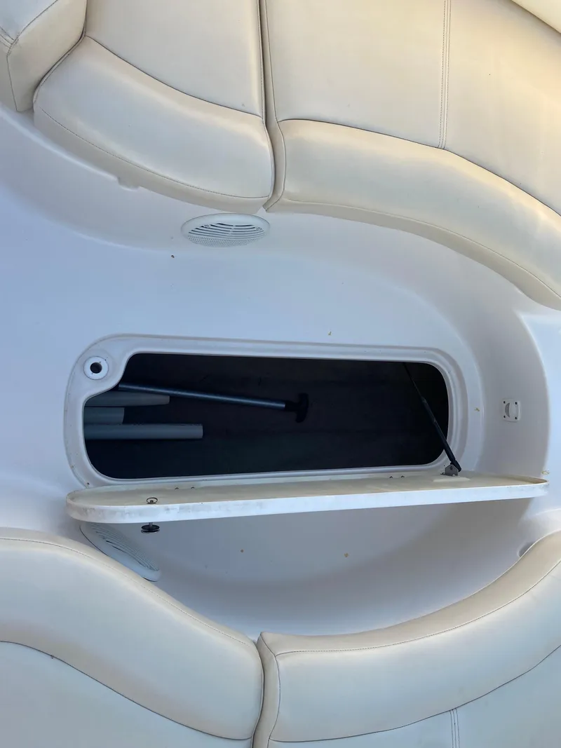 Slide: The Image of 2001 Chaparral Sunesta 232 boat storage compartment with open hatch and beige seating. - 26