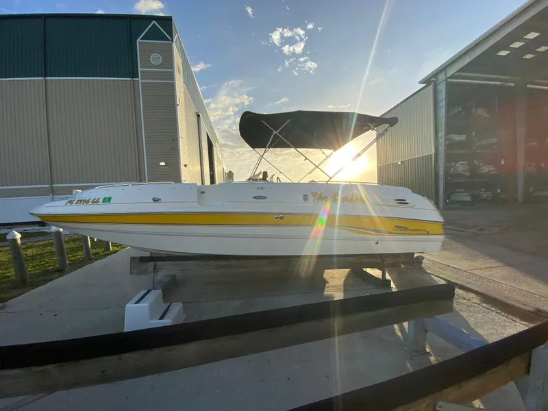 Slide: The Image of 2001 Chaparral Sunesta 232 boat on trailer, sunlit background, near storage facility. - 4