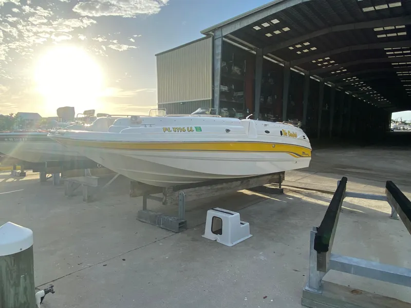 Slide: The Image of 2001 Chaparral Sunesta 232 boat on trailer, sunlit, near large storage facility. - 6