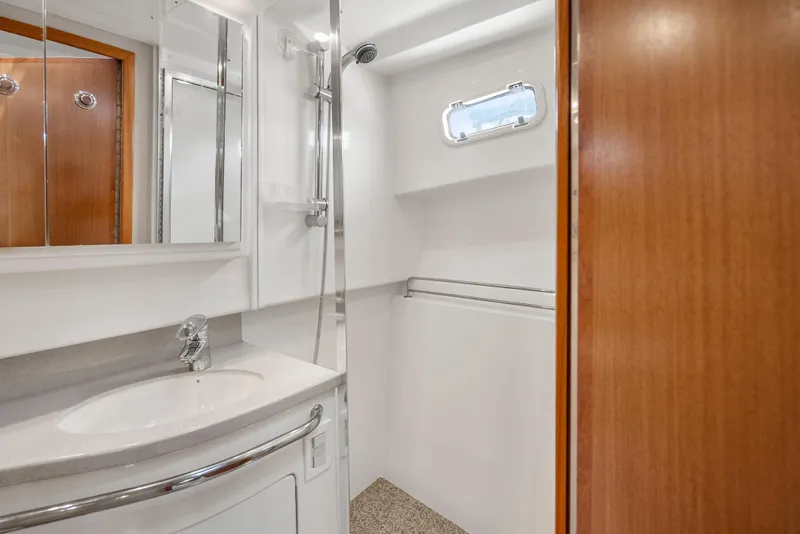 Slide: The Image of 2004 Cabo 40 Express yacht bathroom with shower, sink, and wooden accents. - 14
