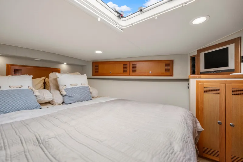 Slide: The Image of Luxurious cabin interior of 2004 Cabo 40 Express yacht with cozy bedding and wooden cabinetry. - 15