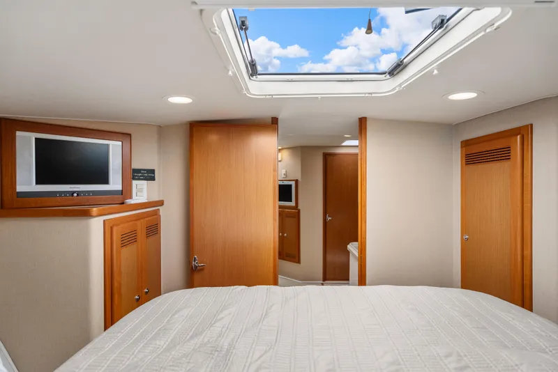 Slide: The Image of Interior of 2004 Cabo 40 Express yacht with skylight, TV, and wooden cabinetry. - 16