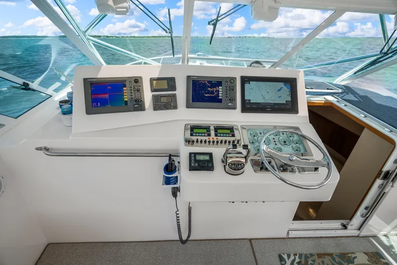 Slide: The Image of Helm of 2004 Cabo 40 Express boat with navigation screens and steering wheel. - 23