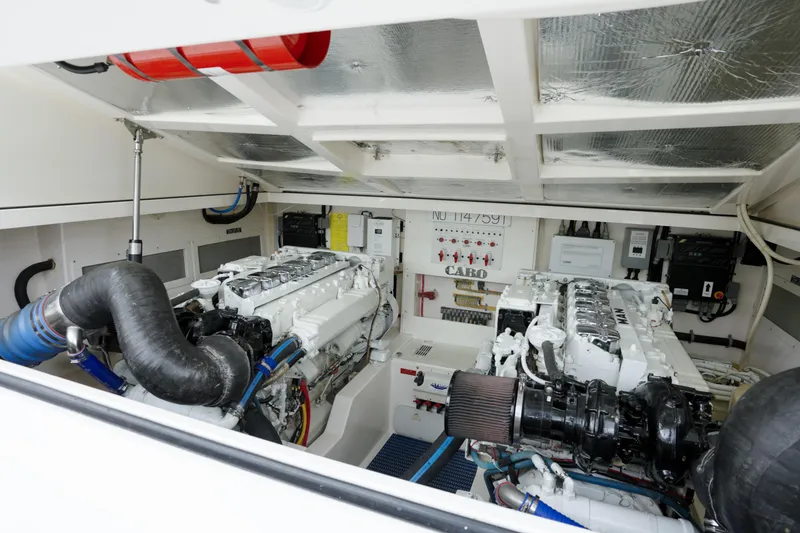 Slide: The Image of Engine room of a 2004 Cabo 40 Express boat, featuring dual engines and mechanical components. - 4