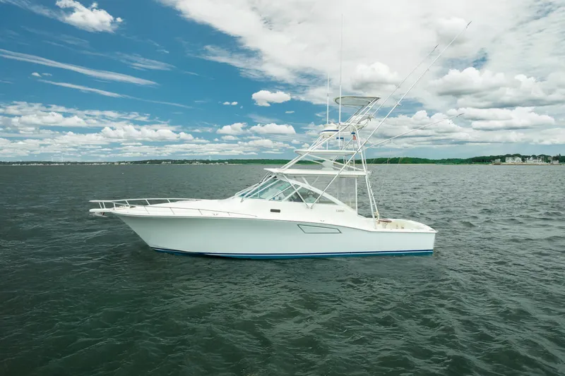 Slide: The Image of 2004 Cabo 40 Express yacht on open water under a partly cloudy sky. - 5