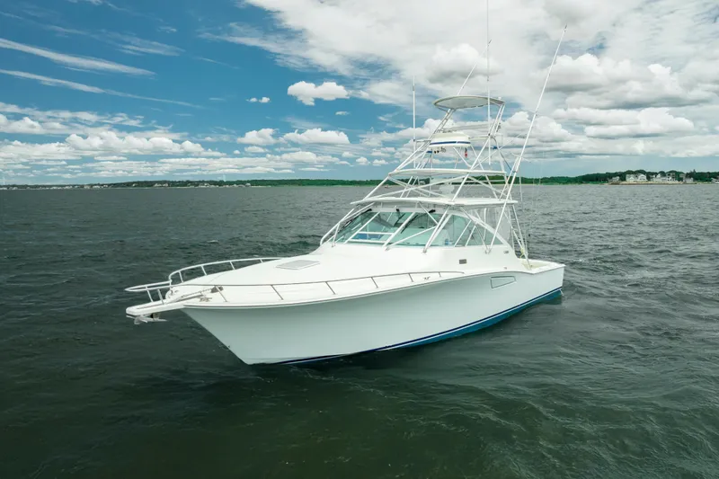 Slide: The Image of 2004 Cabo 40 Express boat on open water under a partly cloudy sky. - 8
