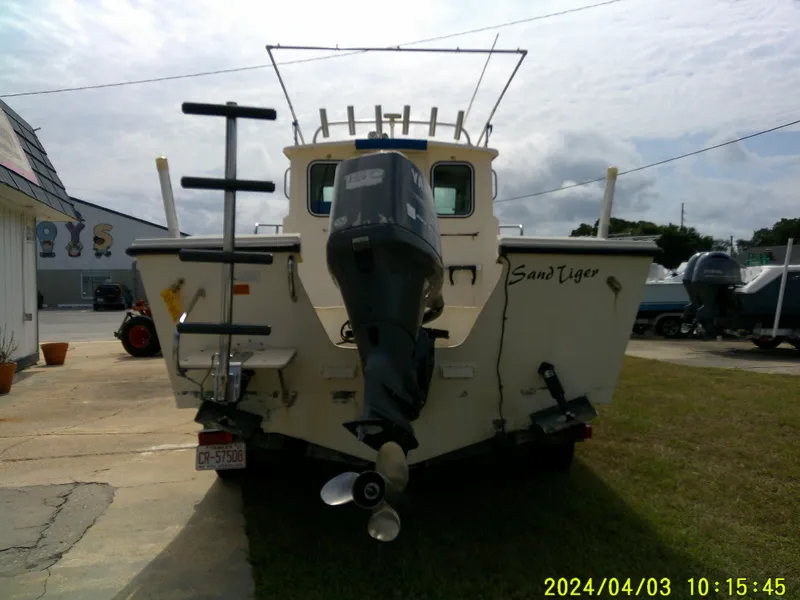 Slide: The Image of 2008 Parker 2120 Sport Cabin boat with outboard motor, parked outdoors. - 10