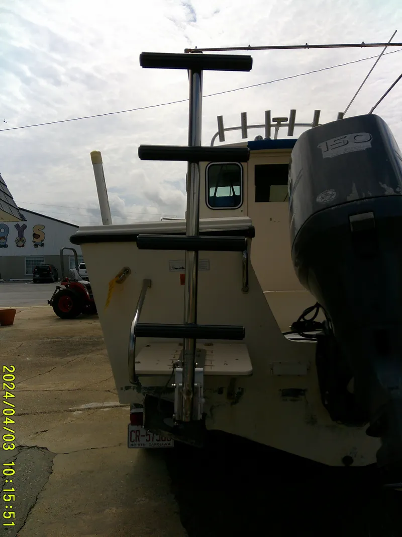 Slide: The Image of 2008 Parker 2120 Sport Cabin boat with outboard motor and ladder. - 11