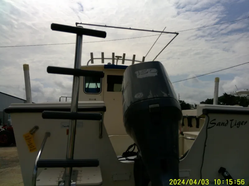 Slide: The Image of 2008 Parker 2120 Sport Cabin boat with outboard motor, docked under cloudy sky. - 12