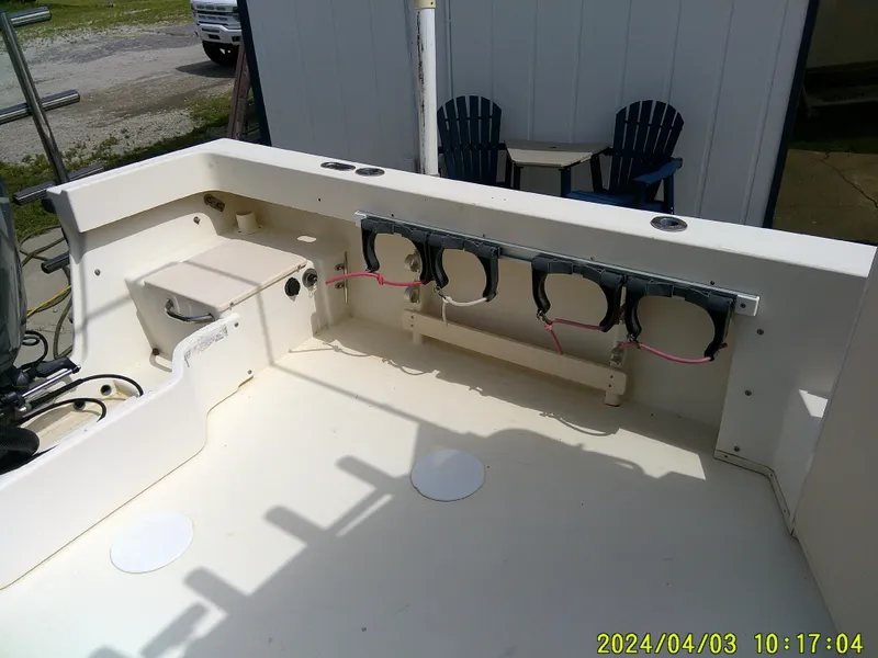 Slide: The Image of 2008 Parker 2120 Sport Cabin boat interior with rod holders and seating area. - 15