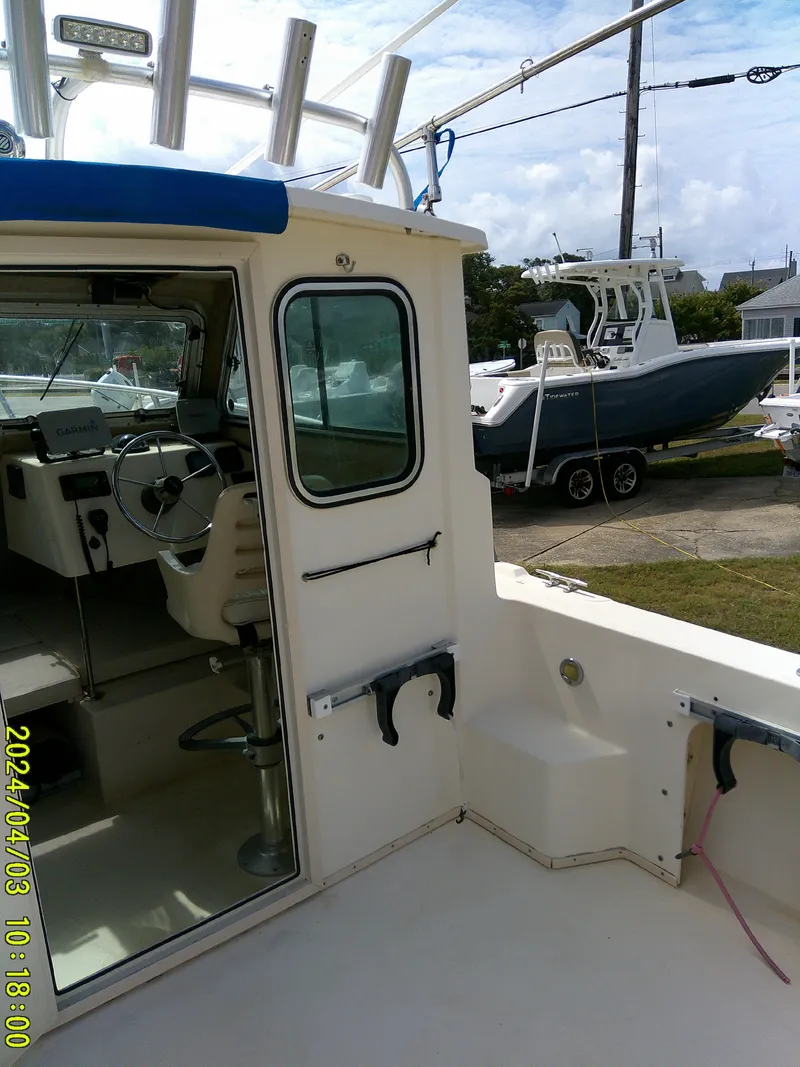 Slide: The Image of 2008 Parker 2120 Sport Cabin boat interior and exterior view at a marina. - 21