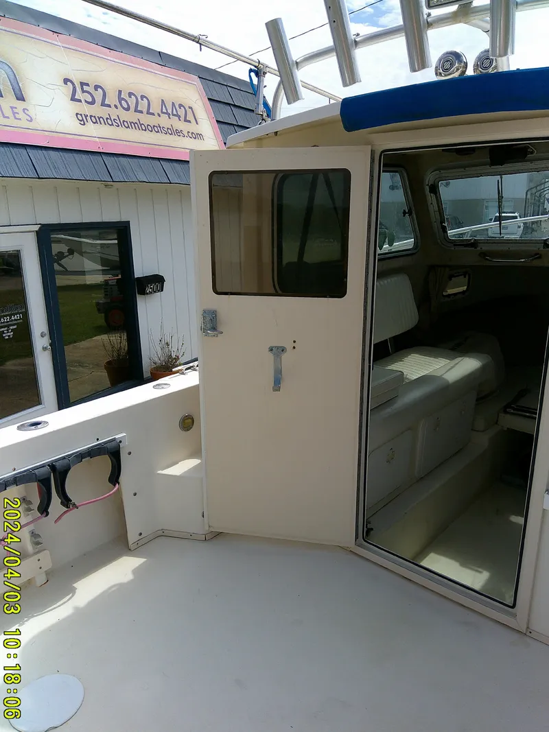 Slide: The Image of 2008 Parker 2120 Sport Cabin boat interior with open door, docked near sales office. - 22