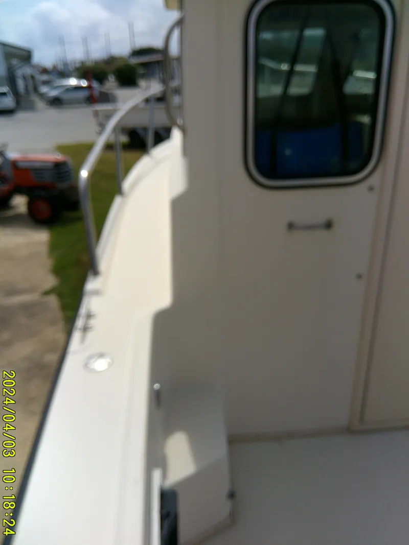Slide: The Image of 2008 Parker 2120 Sport Cabin boat exterior with railing and window. - 24