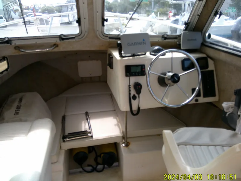 Slide: The Image of Interior of a 2008 Parker 2120 Sport Cabin boat with steering wheel and navigation equipment. - 29