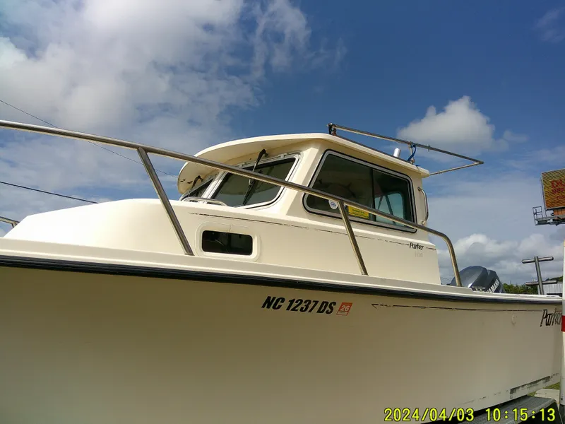 Slide: The Image of 2008 Parker 2120 Sport Cabin boat under a clear blue sky. - 6