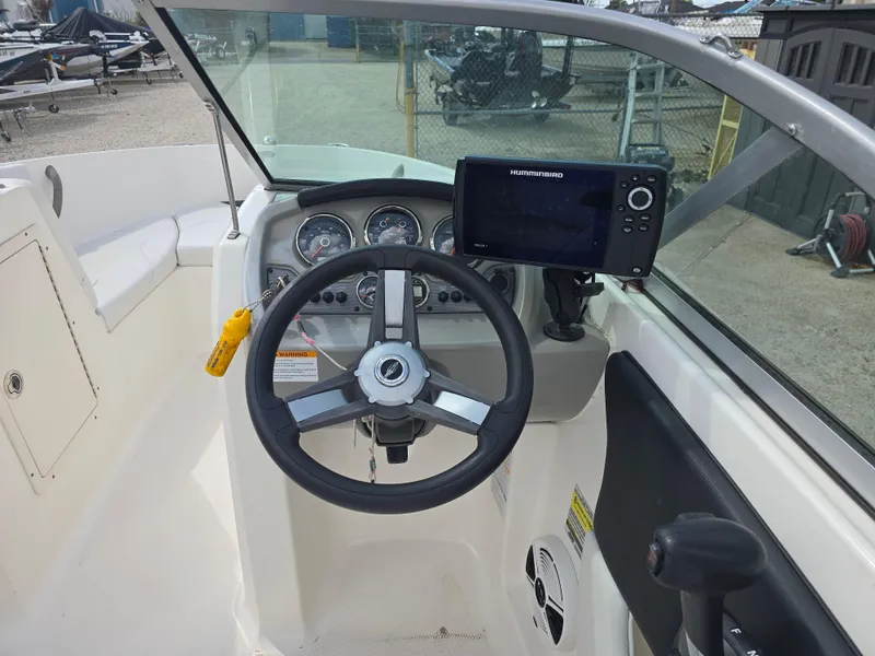 Slide: The Image of 2016 Chaparral 18 H2O Sport boat dashboard with steering wheel and navigation system. - 9