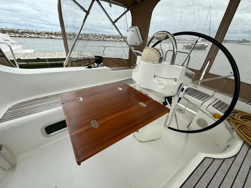 Slide: The Image of Cockpit of 2003 Beneteau 393 sailboat with wooden table and steering wheel. - 16