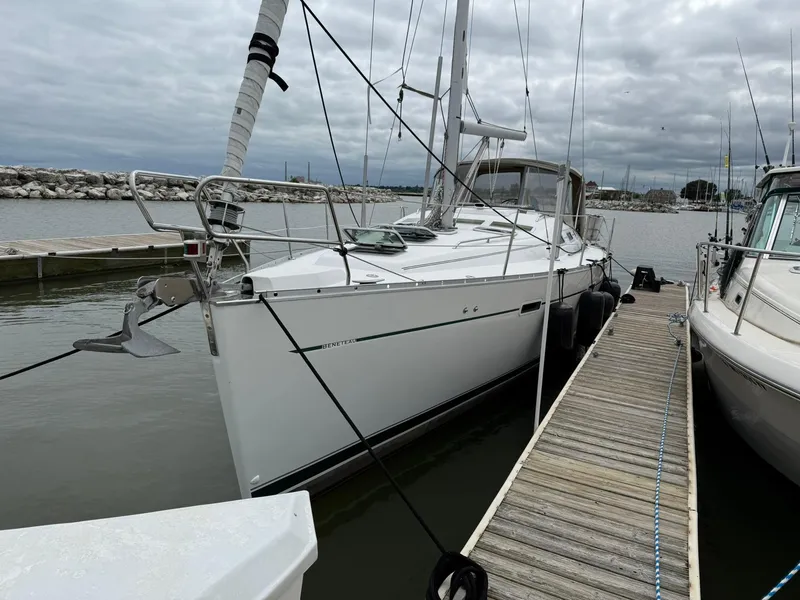 Slide: The Image of 2003 Beneteau 393 sailboat docked at a marina under cloudy skies. - 2