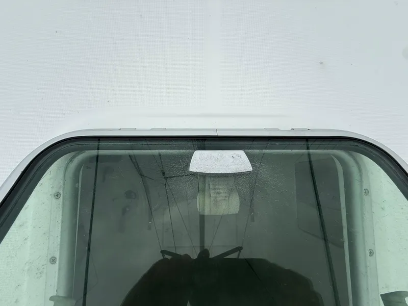 Slide: The Image of Close-up of a 2003 Beneteau 393 boat window with visible reflections. - 31