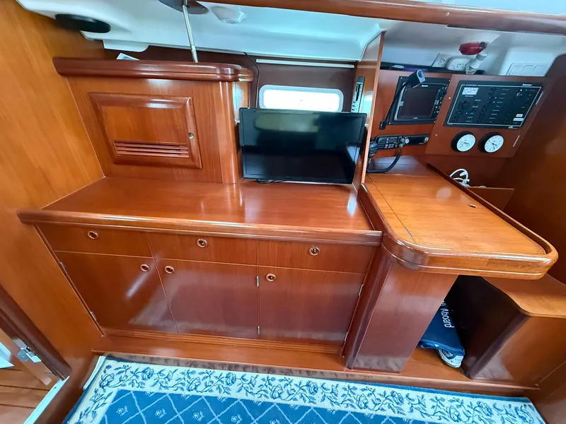 Slide: The Image of Interior of 2003 Beneteau 393 yacht with wooden cabinetry and navigation equipment. - 34