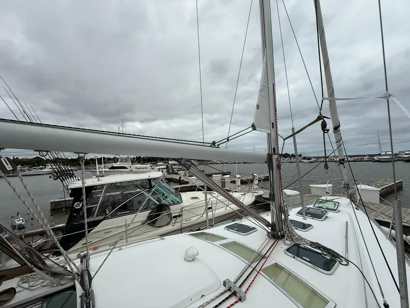 Slide: The Image of 2003 Beneteau 393 sailboat docked at marina under cloudy skies. - 4