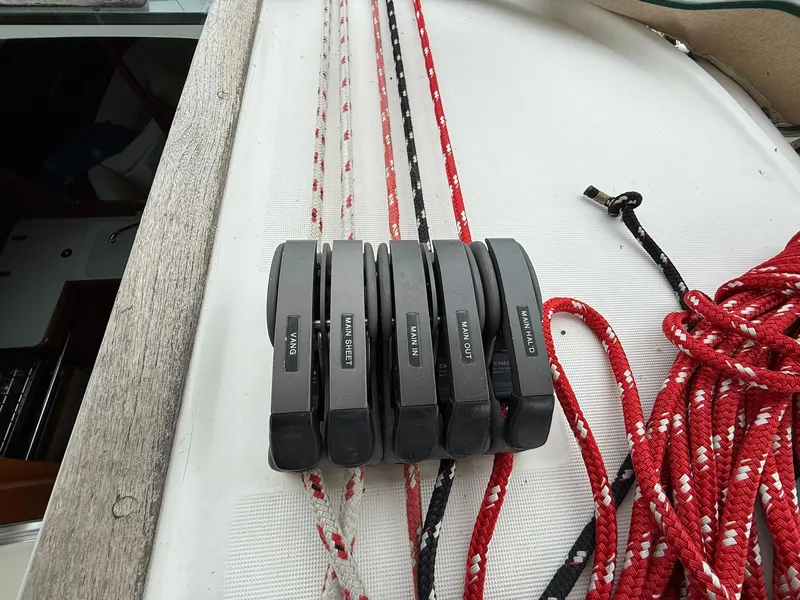 Slide: The Image of Rope clutches on a 2003 Beneteau 393 sailboat deck, featuring labeled lines and colorful ropes. - 6