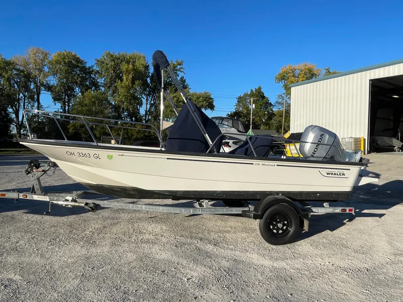 Slide: The Image of 2008 Boston Whaler 170 Montauk boat on trailer, parked outdoors near a building. - 10