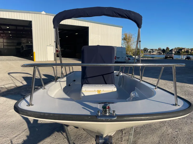 Slide: The Image of 2008 Boston Whaler 170 Montauk boat docked near a warehouse under clear blue sky. - 12