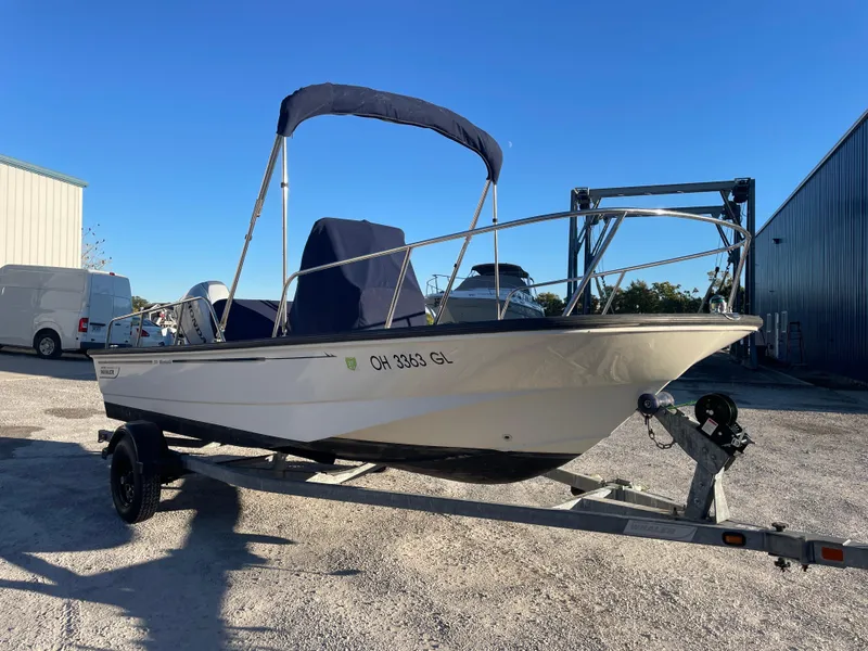 Slide: The Image of 2008 Boston Whaler 170 Montauk boat on trailer, parked outdoors under clear blue sky. - 13