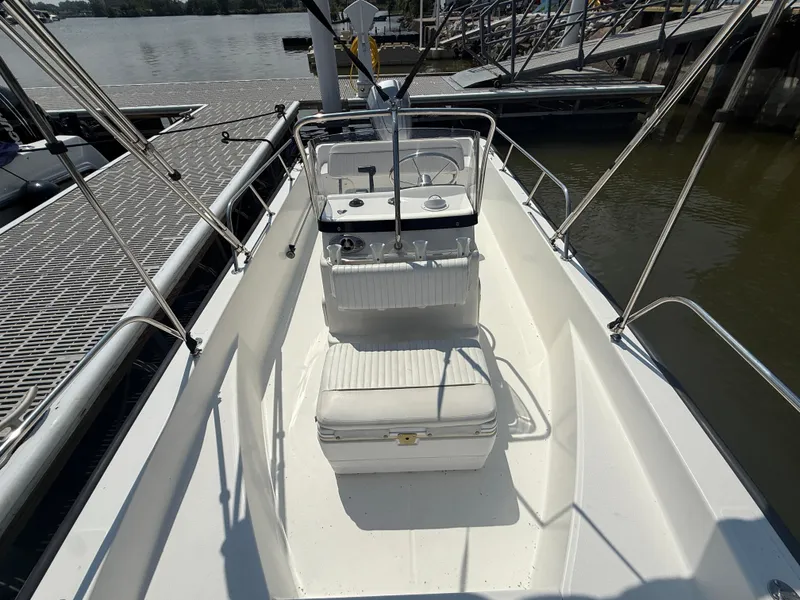 Slide: The Image of 2008 Boston Whaler 170 Montauk boat interior at dock, featuring seating and steering console. - 4