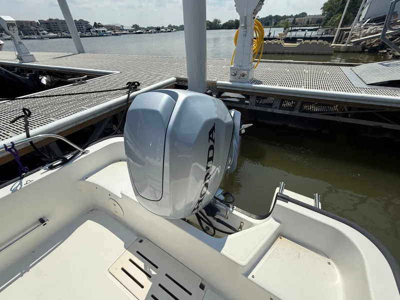 Slide: The Image of 2008 Boston Whaler 170 Montauk with Honda outboard motor docked by the water. - 7