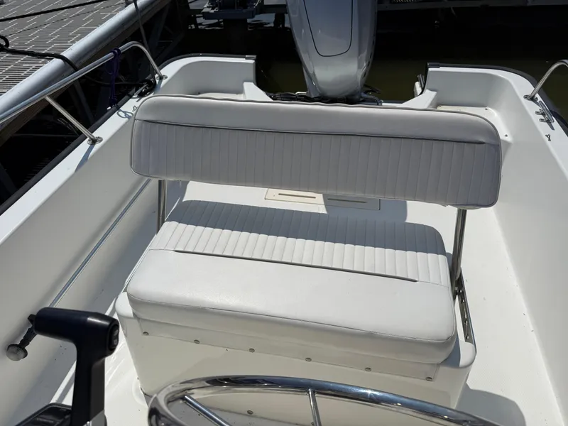 Slide: The Image of 2008 Boston Whaler 170 Montauk boat interior with white seating and steering wheel. - 8