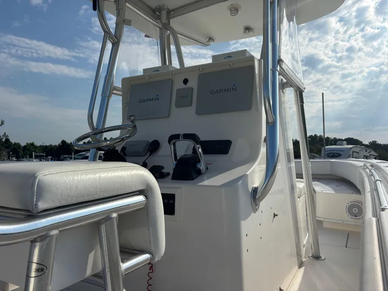 Slide: The Image of 2012 Contender 28 Sport boat console with Garmin navigation, stainless steel frame, and cushioned seating. - 13