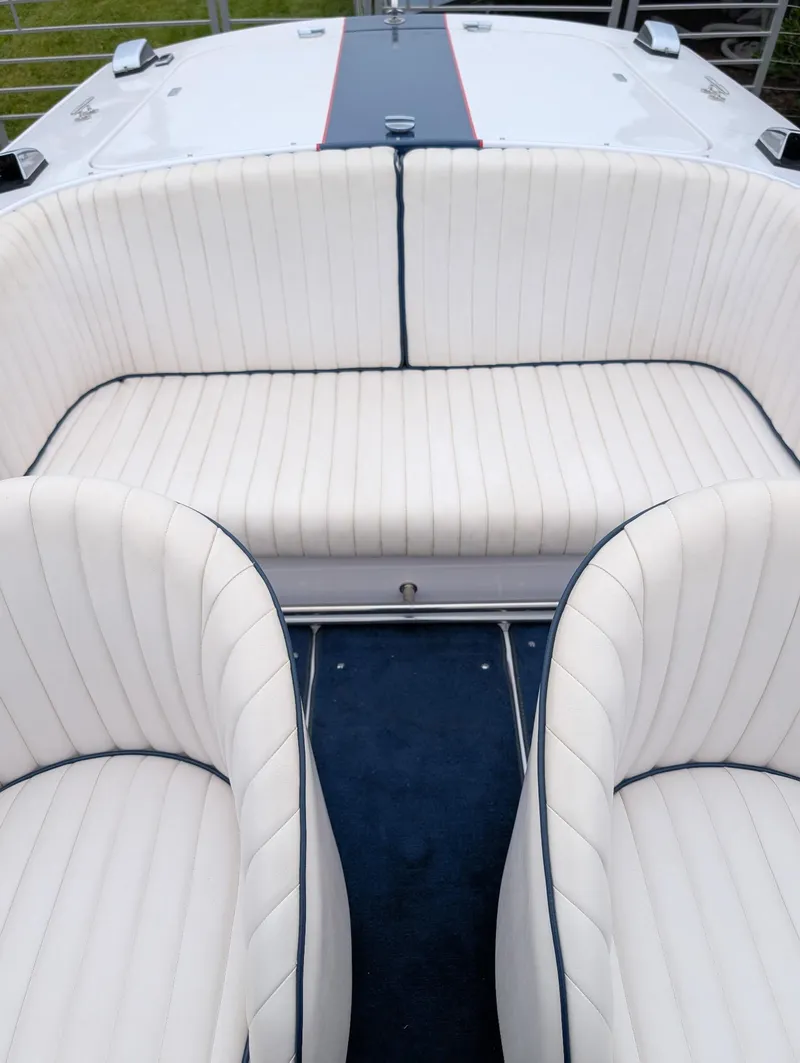 Slide: The Image of 2005 Donzi boat interior with white cushioned seating and blue accents. - 10