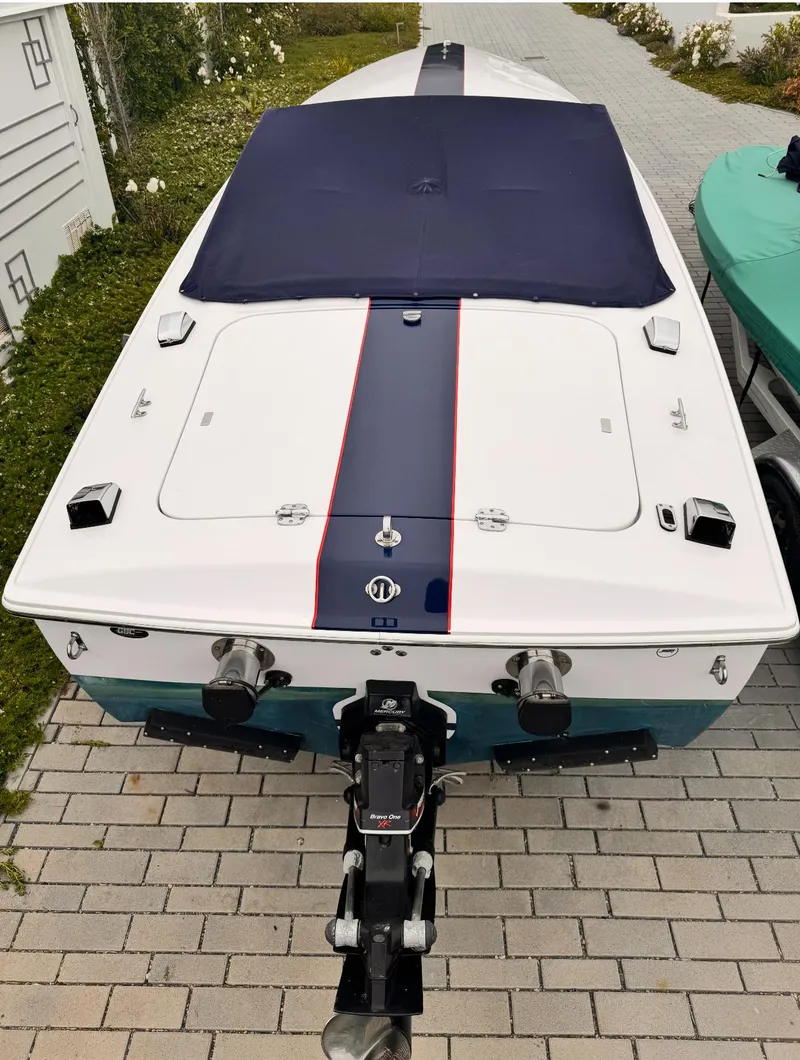 Slide: The Image of 2005 Donzi boat with blue cover and stripe, parked on brick driveway. - 4