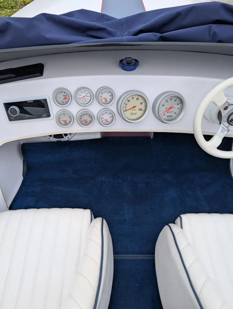 Slide: The Image of Interior of a 2005 Donzi boat with gauges and white seating. - 6