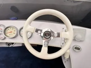 Slide: The Image of 2005 Donzi boat dashboard with white steering wheel and gauges. - 7