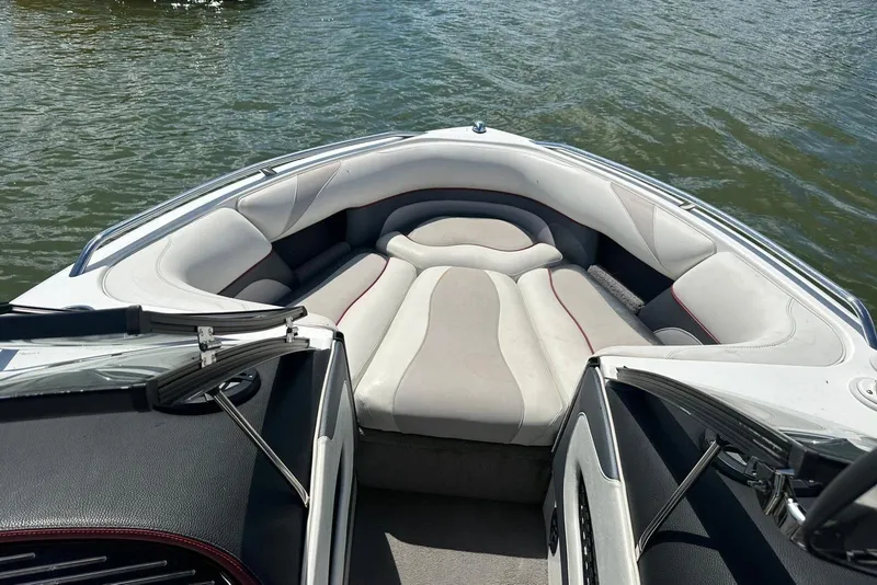 Slide: The Image of 2008 Malibu Wakesetter VTX boat interior with cushioned seating on calm water. - 19