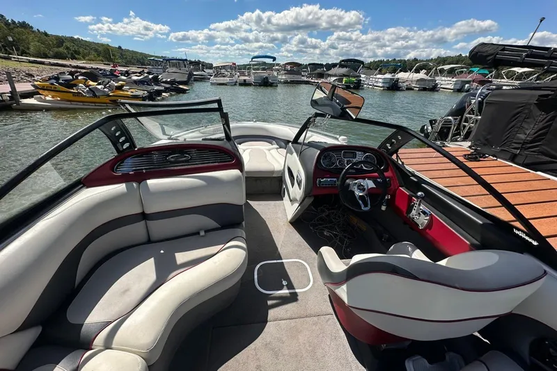 Slide: The Image of 2008 Malibu Wakesetter VTX interior at a marina with boats and jet skis. - 21