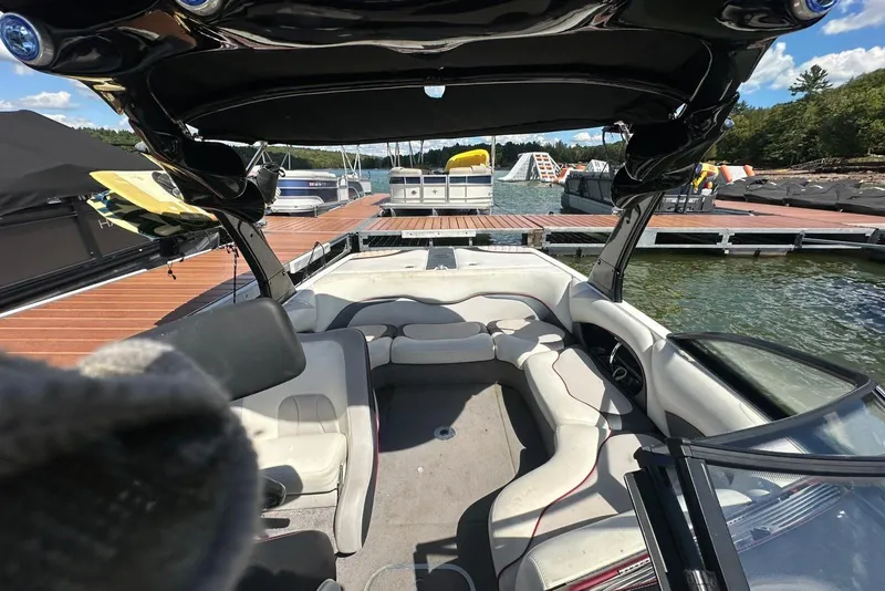 Slide: The Image of 2008 Malibu Wakesetter VTX boat interior at dock, featuring spacious seating and sleek design. - 23