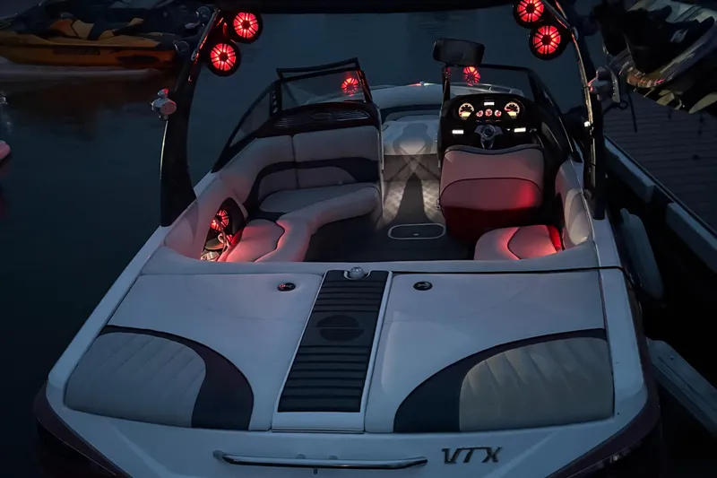 Slide: The Image of 2008 Malibu Wakesetter VTX boat with illuminated interior and sleek design at night. - 4