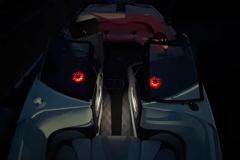 Slide: The Image of 2008 Malibu Wakesetter VTX boat docked at night with red and white design. - 2