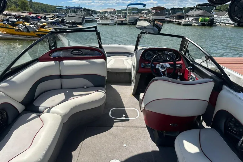 Slide: The Image of 2008 Malibu Wakesetter VTX interior with seating and dashboard, docked near other boats. - 22