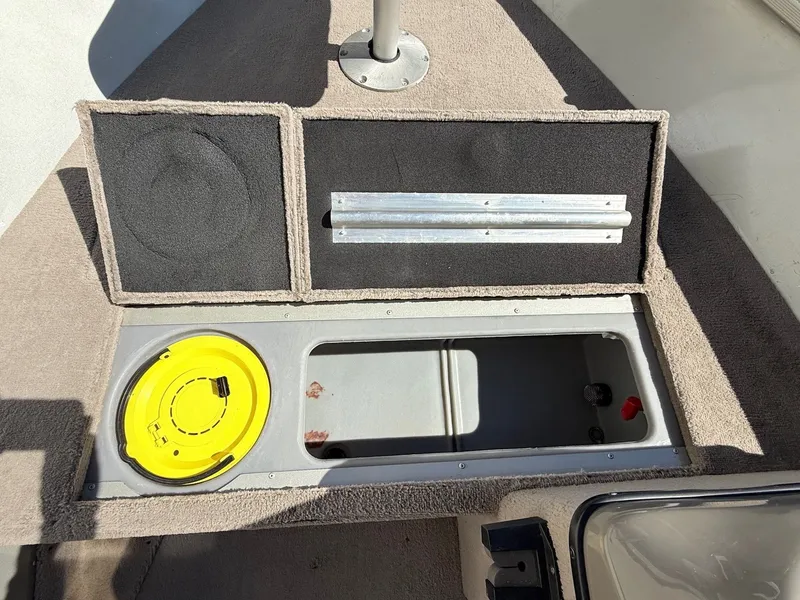 Slide: The Image of 2005 Bass Tracker PGV16 boat storage compartment with yellow lid and carpeted interior. - 13