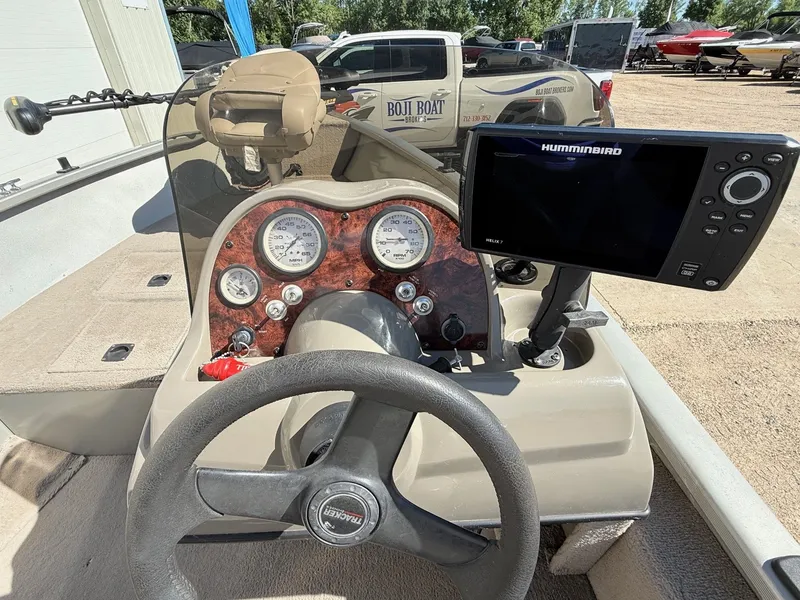 Slide: The Image of 2005 Bass Tracker PGV16 boat dashboard with steering wheel and Humminbird Helix 7 fish finder. - 16