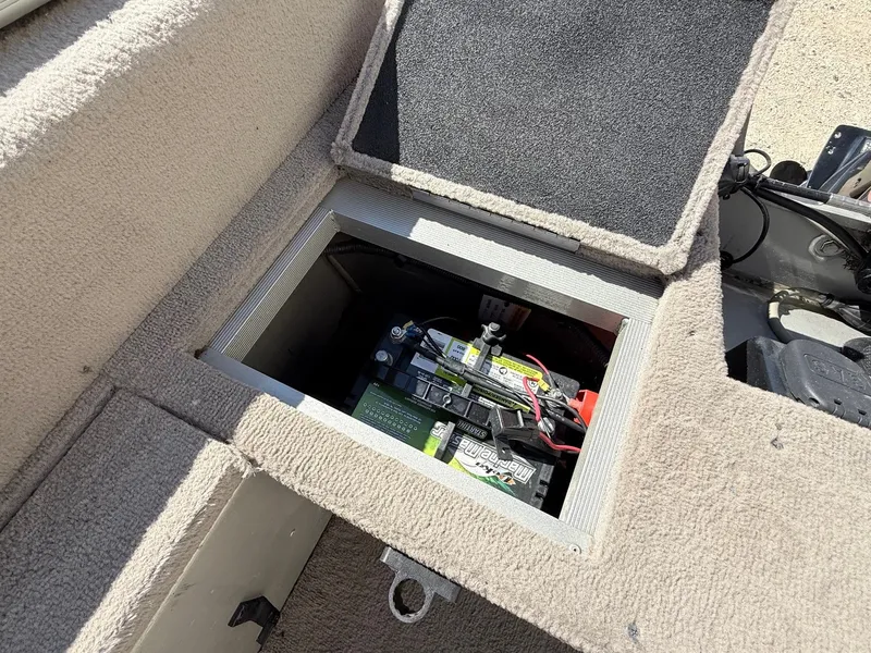 Slide: The Image of 2005 Bass Tracker PGV16 boat battery compartment with open hatch, revealing marine battery. - 19