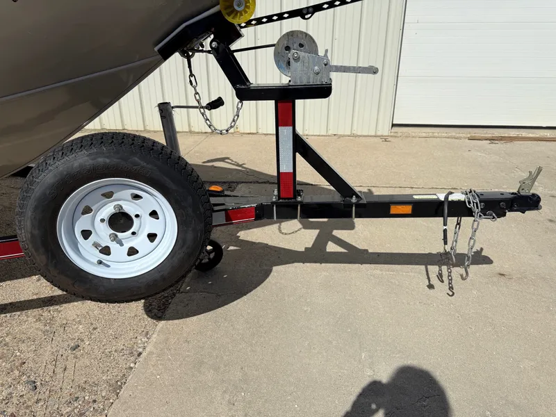 Slide: The Image of Trailer hitch and wheel of a 2005 Bass Tracker PGV16 boat on concrete surface. - 22