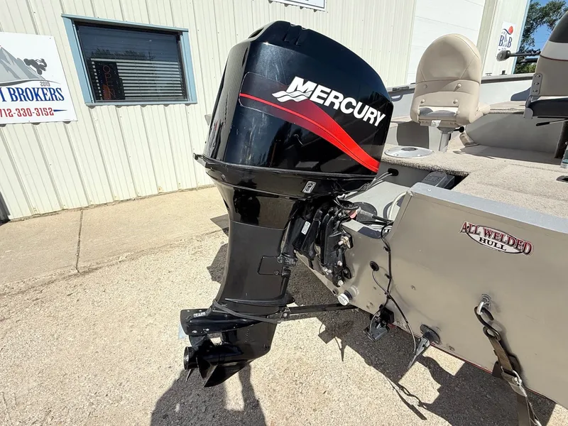 Slide: The Image of 2005 Bass Tracker PGV16 boat with Mercury outboard motor, all-welded hull, parked outside. - 8